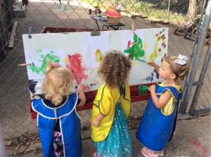 Three children painting outside