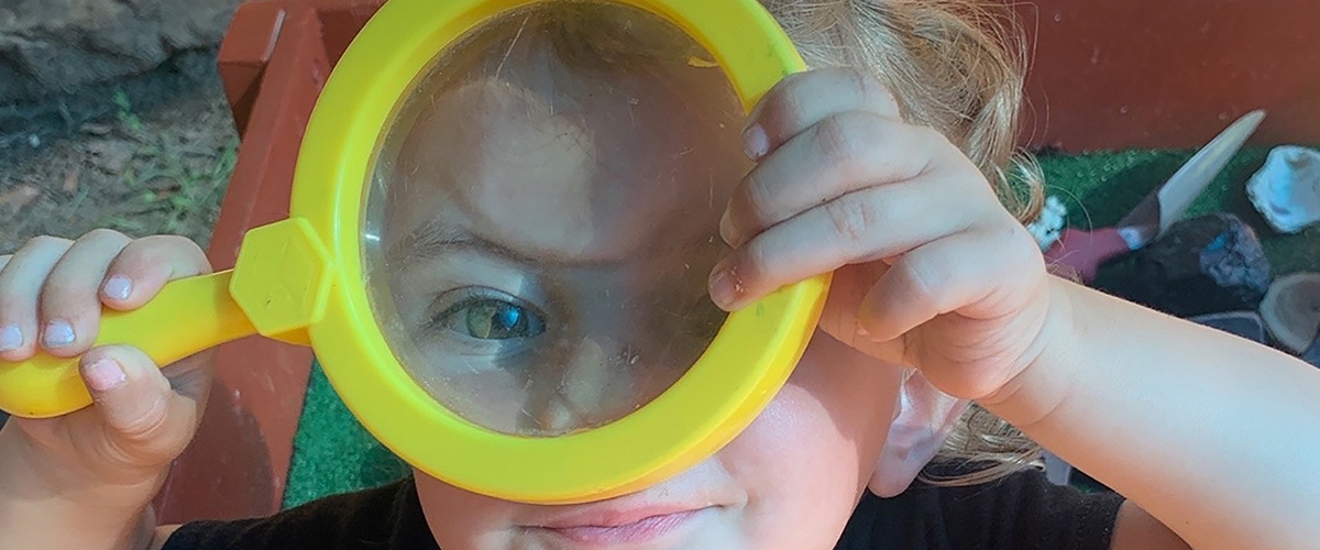 Child with magnifying glass