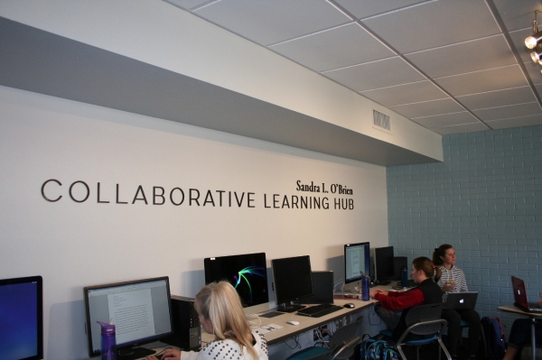 Wall sign and computer workstations at the Sandra L. O'Brien Collaborative Learning Hub
