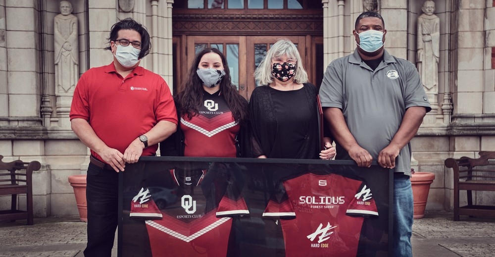 Director Moog, Kara Brightwell, Momma Solidus, Ricky McNeal holding Solidus framed jersey.