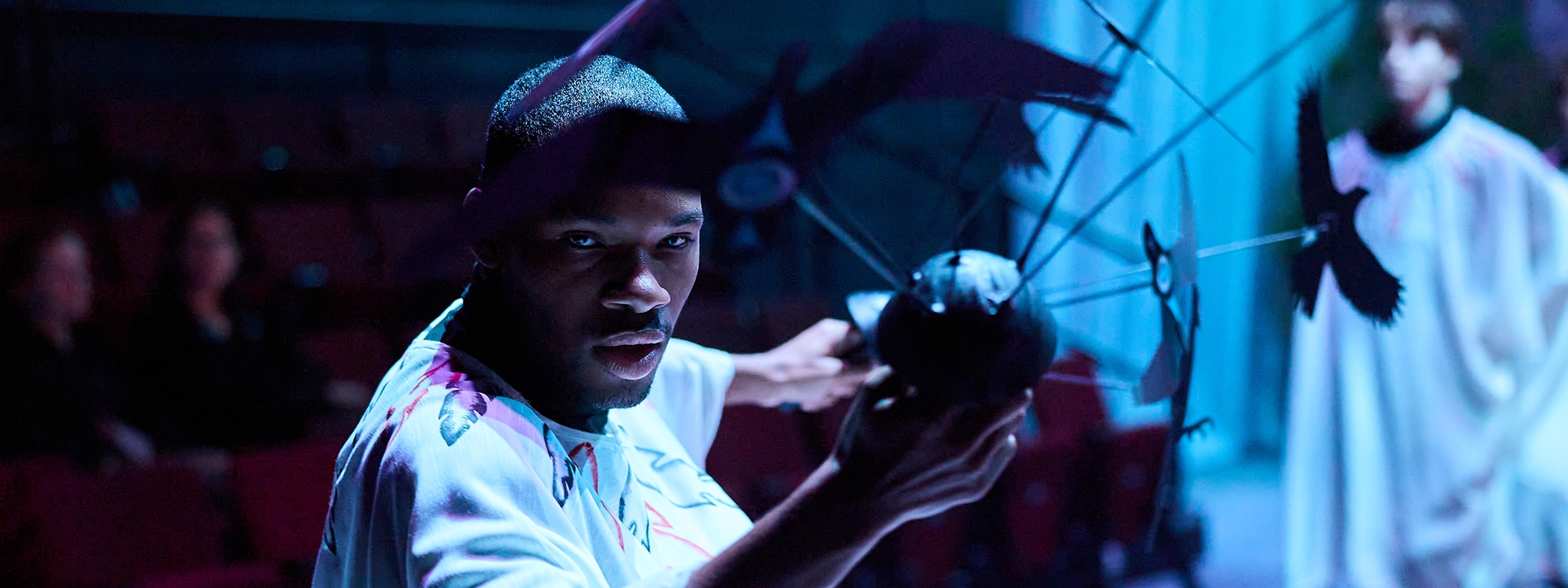 A drama student holding a prop in a dress rehearsal of The Birds.