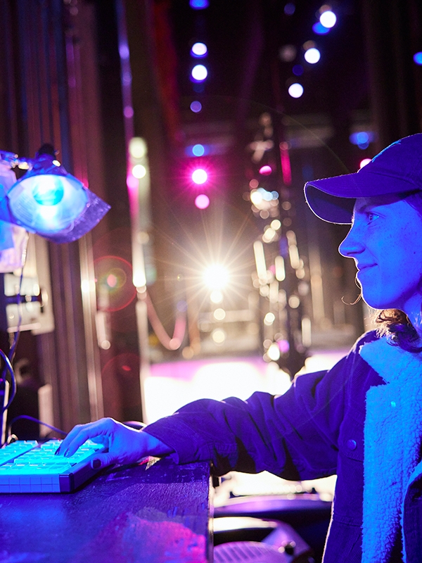 A person working with lighting equipment backstage.