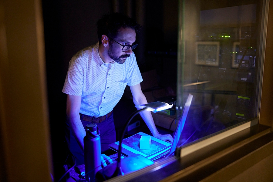 A professor working with equipment backstage during a performance.