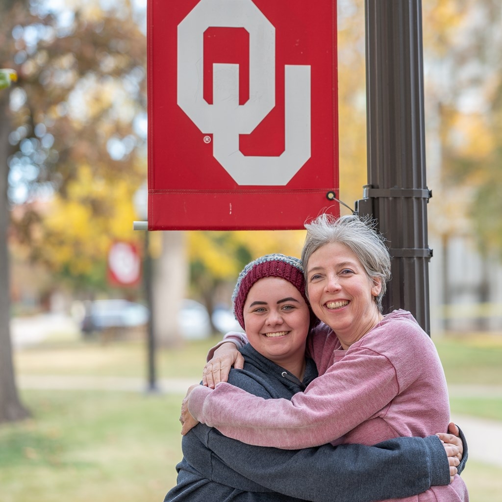 Dr. Watts with Student outdoors near an OU lamp post.
