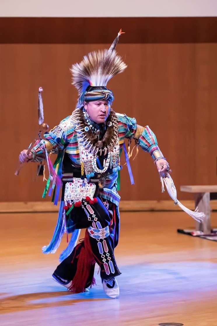 Male Native American dancer in traditional ceremonial attire.