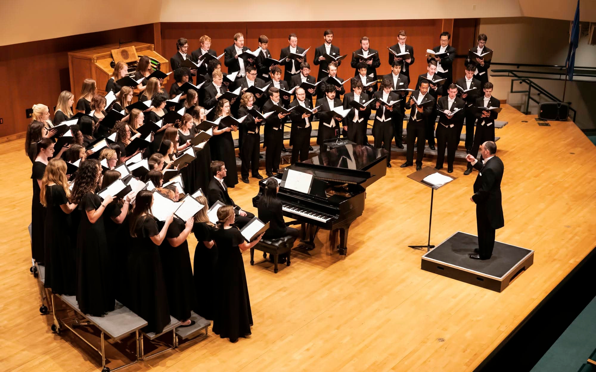 Large combined choir performs in sharp hall.