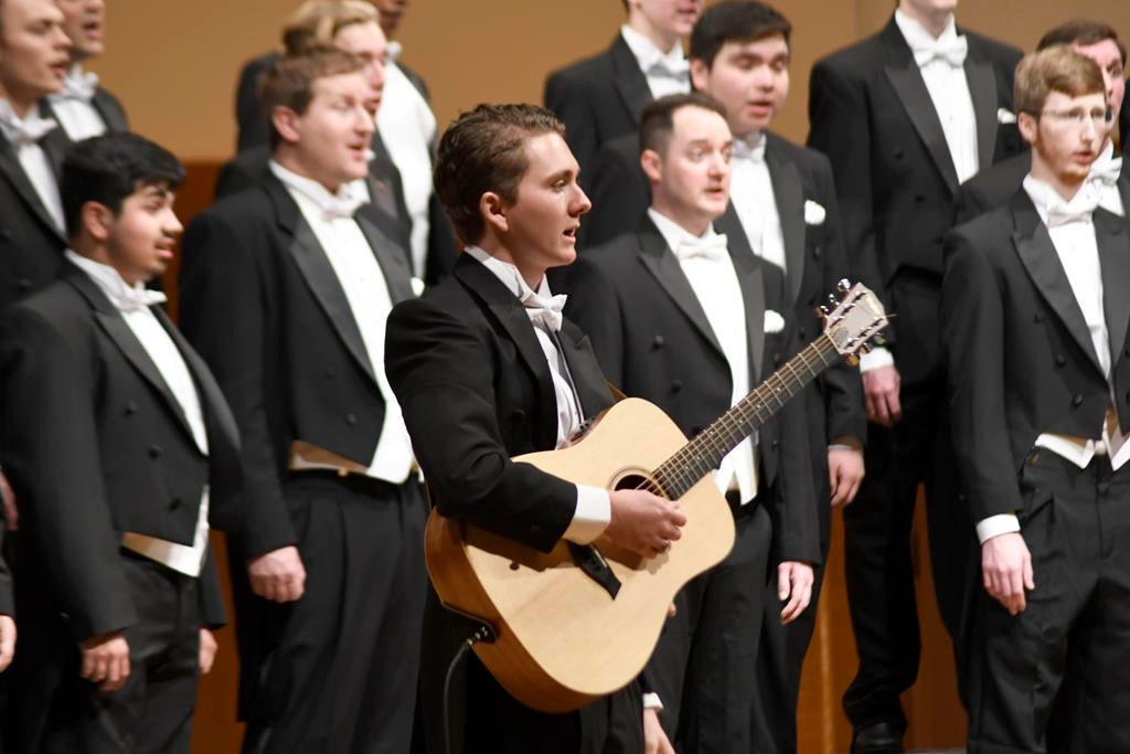 Glee Club performing in Sharp Hall with guitarist.