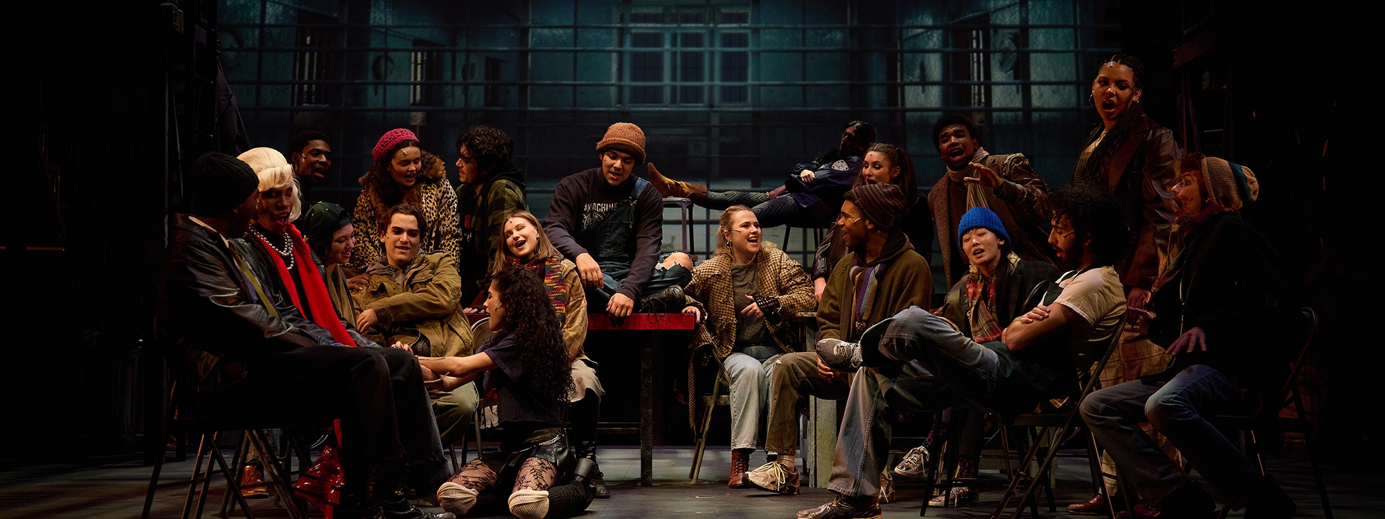 Musical theatre students performing on stage in a production of RENT.