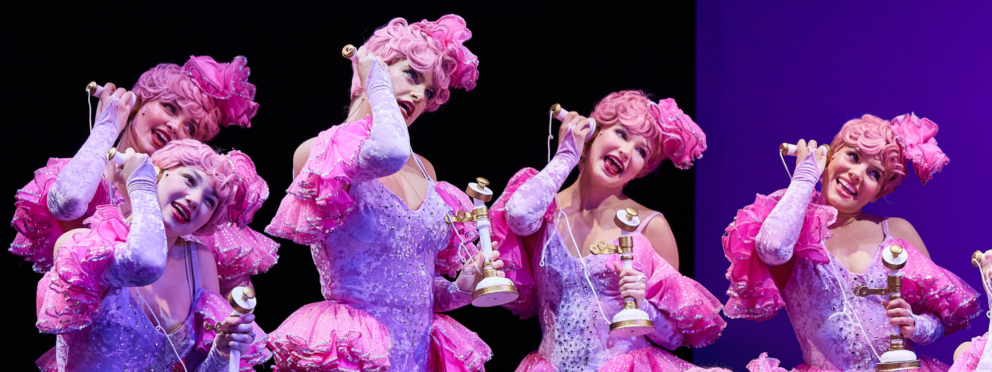 Crazy for You actors singing into phones.