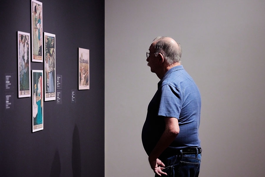 A museum patron looking at a wall of art.