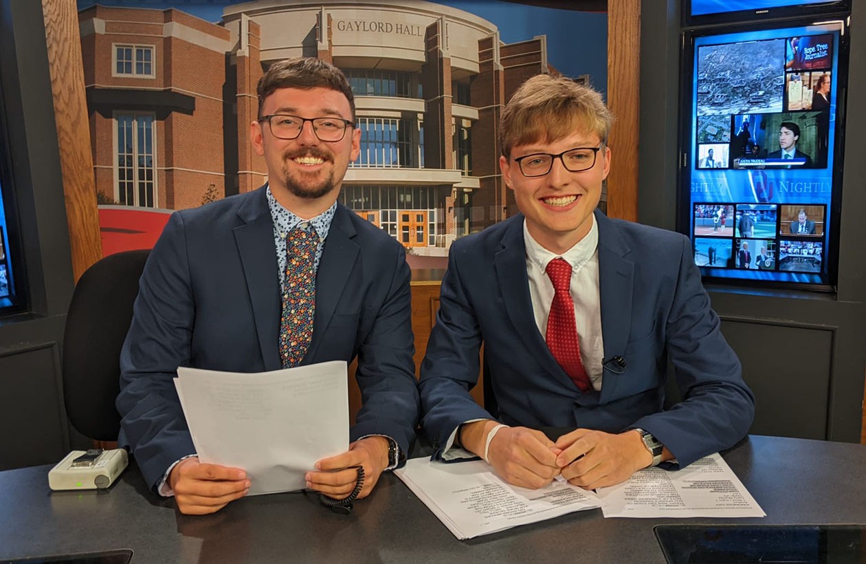 Harry and Adam sitting at the OU Nightly desk in Gaylord College.