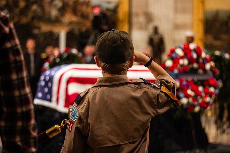 Eliot Dupree of Cub Scout Pack 116 in Arlington, VA salutes at the casket of former President George H.W. Bush. (Megan Ross / Gaylord News)