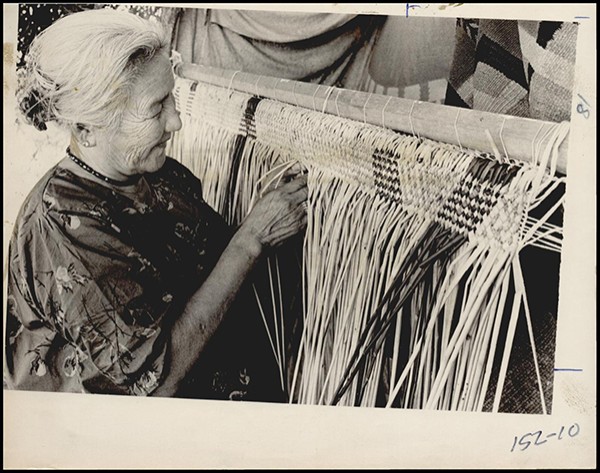 FAIR \ STATE \ INDIAN VILLAGE: ANCIENT ART: Caption reads, Ancient art of weaving is conducted at the State Fair of Oklahoma by Mrs. grace Stevens, a Kickapoo Indian from Shawnee, who works in the Indian Village on the Oklahoma City fairgrounds, spending about five days to weave a large mat from reeds.  Staff Photo by Paul Derby. Original Photo 09/24/1966. Published on O-9-27-66.