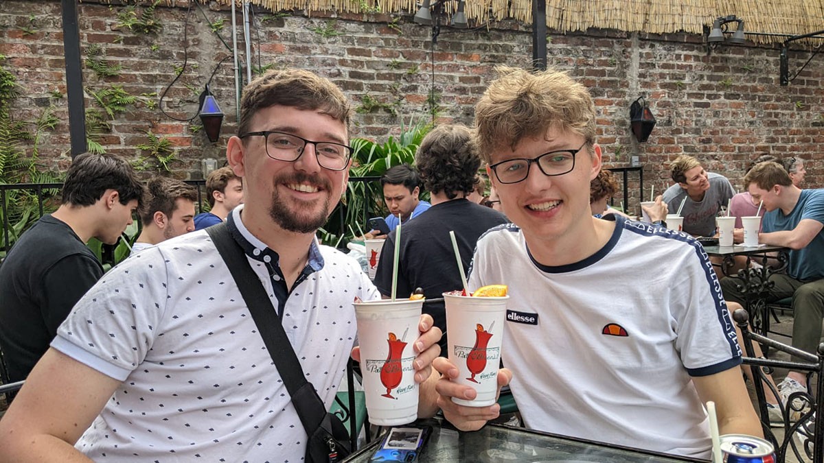 Harry and Adam smiling, drinking sodas.
