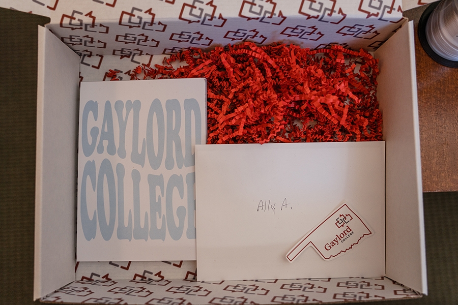 Gaylord college admission box with red confetti and gaylord college sticker