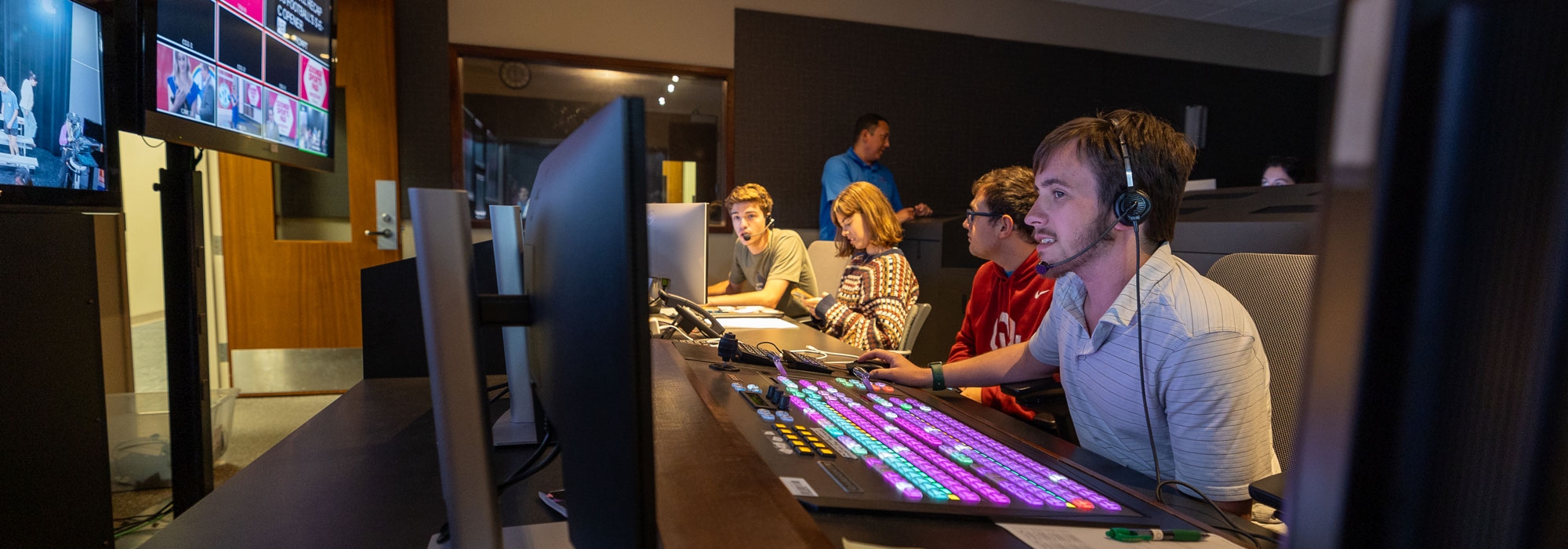 A group of students working in the Sooner Sports Pad control room.