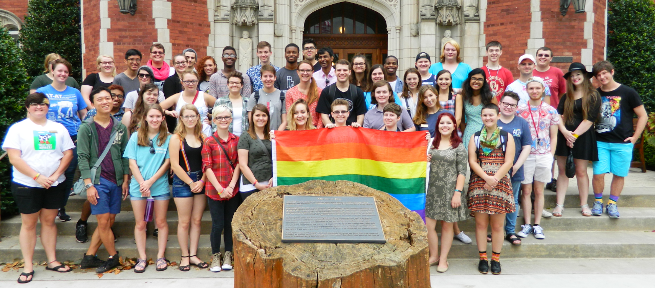 Students holding a Pride flag in front of Evans Hall