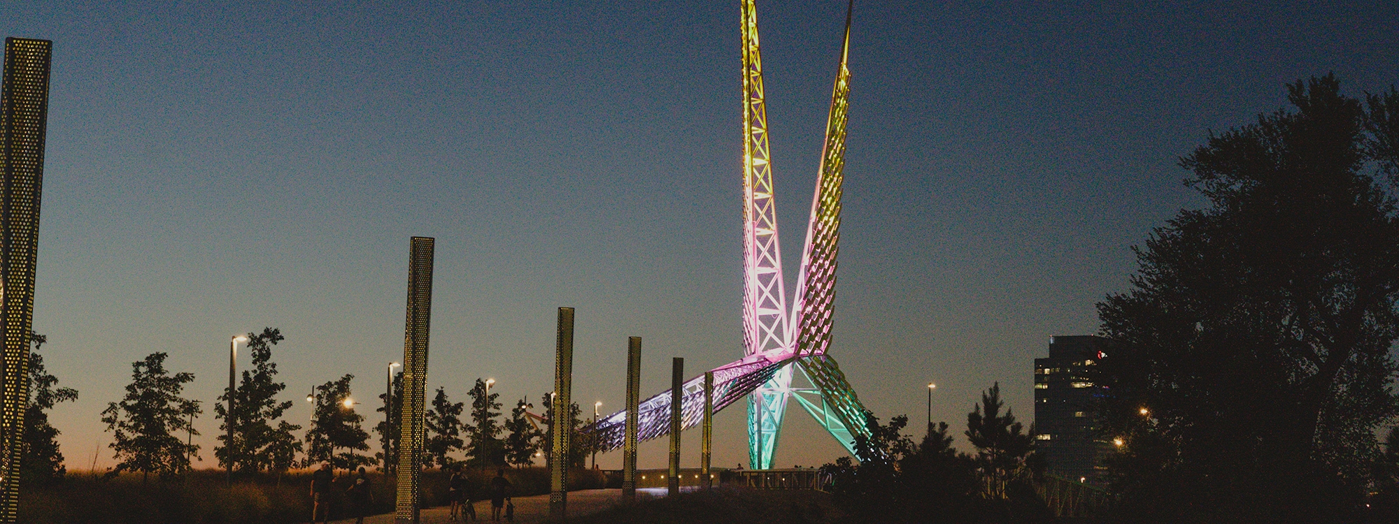 The Skydance Bridge at night, illuminated in various colors.