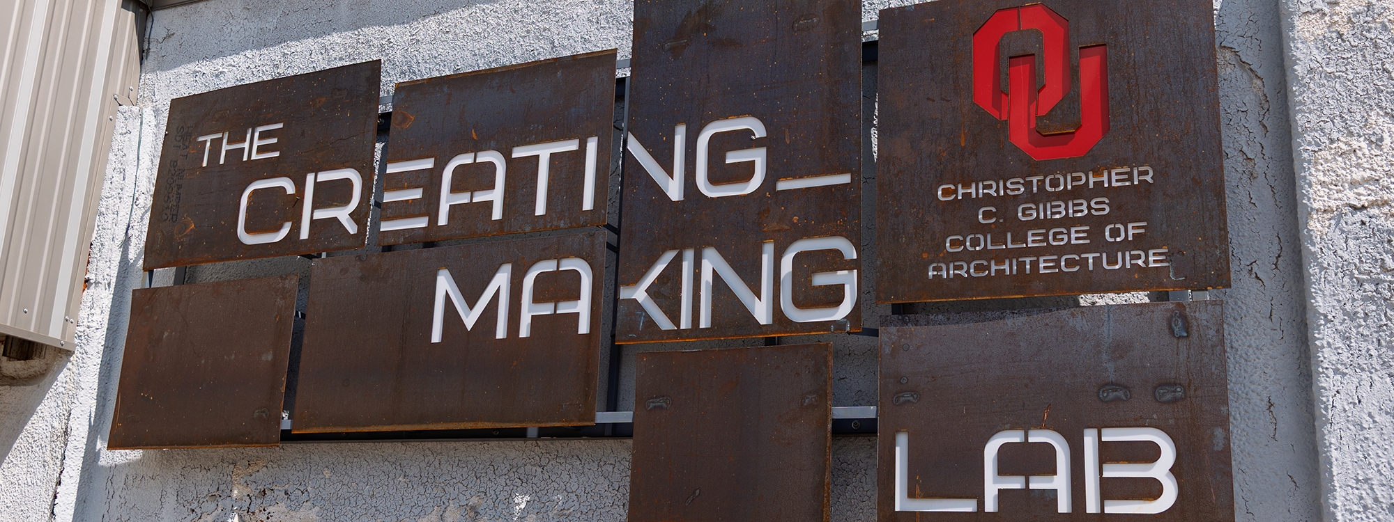 A group of people at a table, working with various materials.