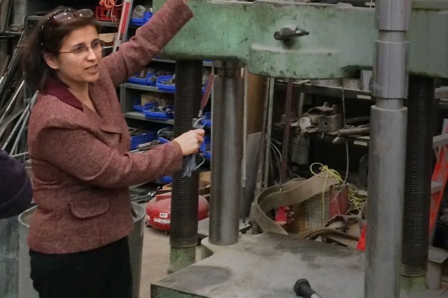 Picture of Shideh Shadravan discussing something at a hydraulic press.