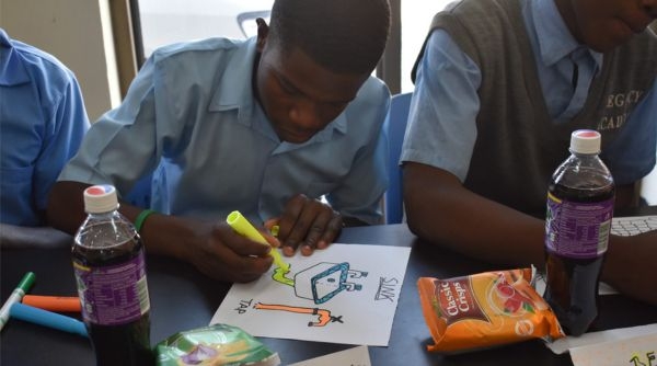 Picture of students from Lusaka illustrating with drawings on paper desired facilities.