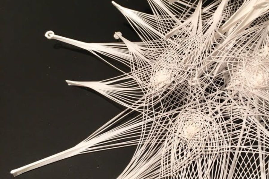 A conceptual architectural model that is made of a wooden web like substance against a black background