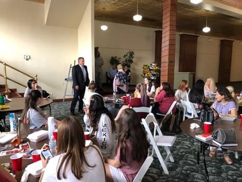 Interior design students seated at tables during their site visit to Woodward Theatre.