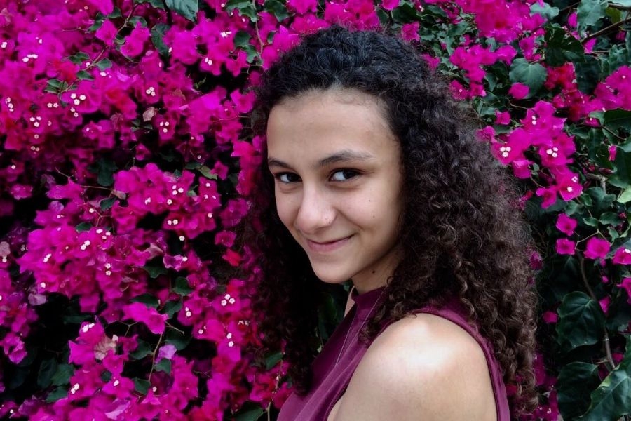 Headshot of Kristi Saliba in front of purple flower bush.