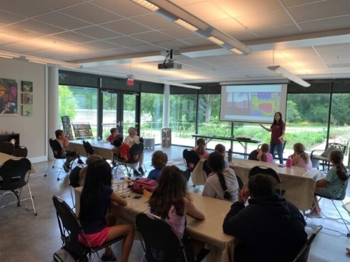 Cheng giving a guest lecture for a group of children in a classroom. 