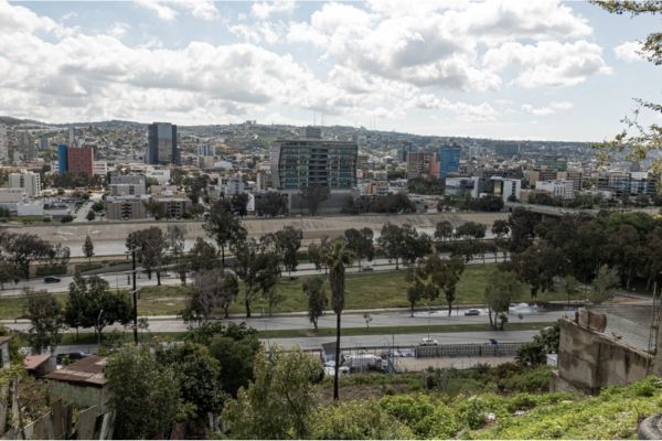 City skyline with river channel and highway from hillside viewpoint