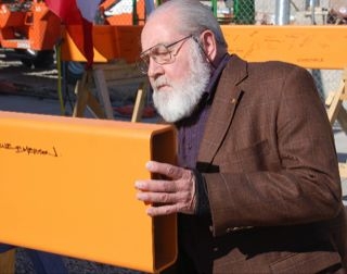 Jim Sealy signing a steel beam.
