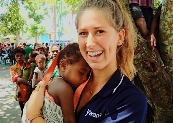 Chanae Carter with a baby and other clients at a medical clinic.