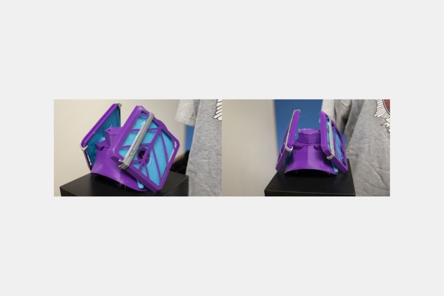 A purple 3 D printed face mask with blue filters.