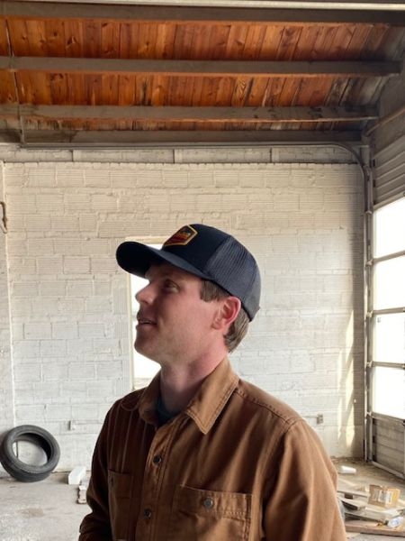 Cameron Brewer looking up at the ceiling inside a building that is under redevelopment construction.