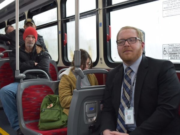Taylor Johnson sitting in a Norman Public bus engaging with other bus riders.