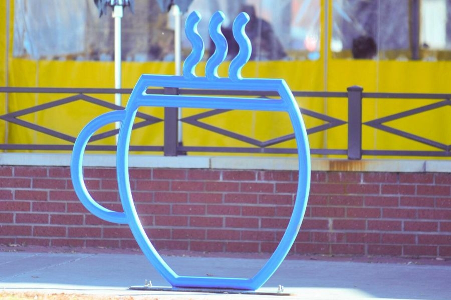 Picture of Norman bicycle rack that is designed to look like a cup of coffee, acting also as a street design element
