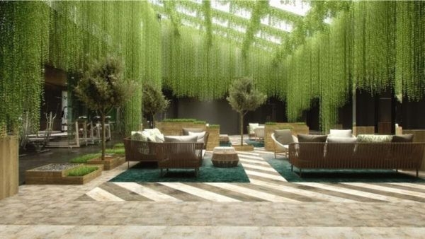 Picture of grand interior space with lush green plants coming from ceiling, giving an indoor jungle feel.