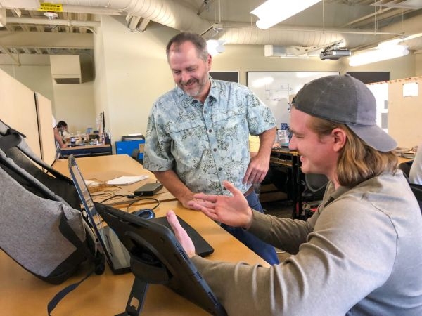 Sam Callahan working with student Tyler Kohl at a desk.