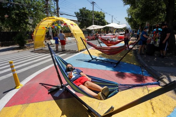 A child lays in a hammock in a closed street.
