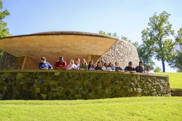 A group photo by a stone building.