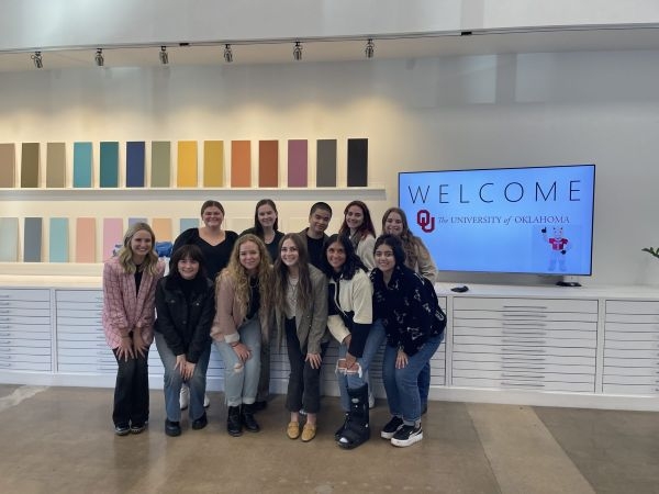 O U interior design students with a sign welcoming them.