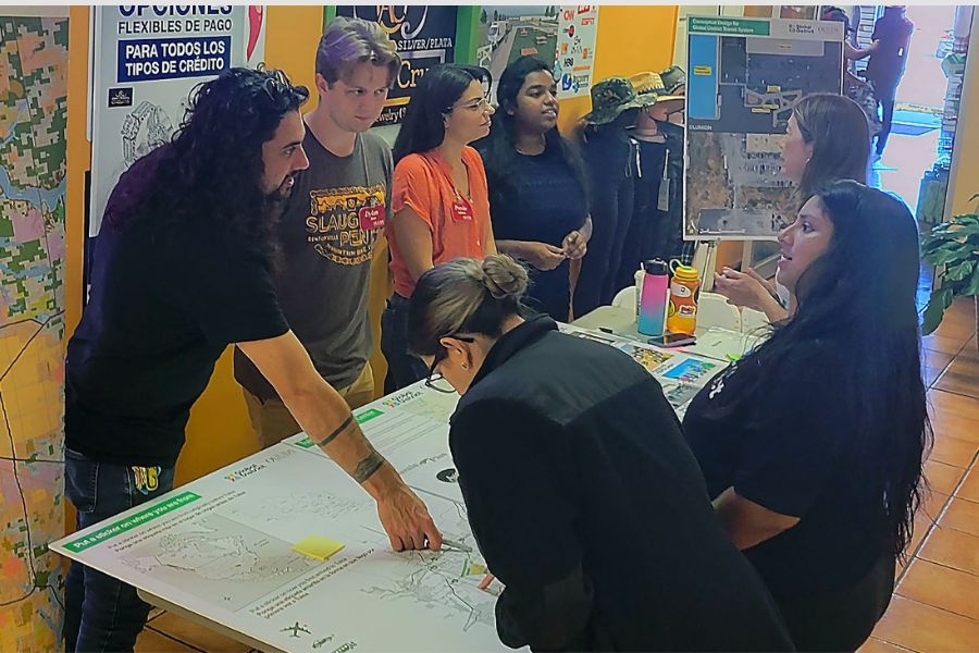 Urban Design students engaging with Tulsa community members around a table with designs and plans. 