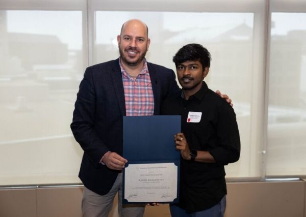 Rajith Kumar Kedarisetty receiving a certificate recognizing him as an Olmsted Scholar.