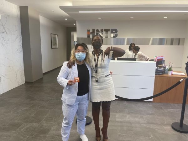 Grace Olaleye and an intern in an H N T B lobby.