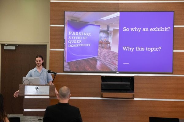 Ryan Godfrey with a presentation slide showing the exhibit "Passing: A Study of Queer Domesticity" with the text "So why an Exhibit? Why this topic?".