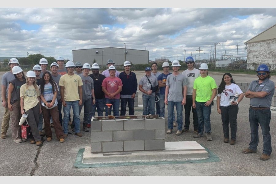 Construction students in hard hats with concrete masonry units.