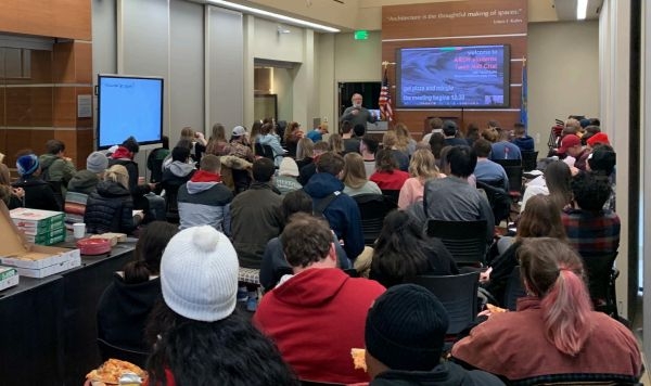 Daniel Butko at the front of a crowded architecture student town hall.