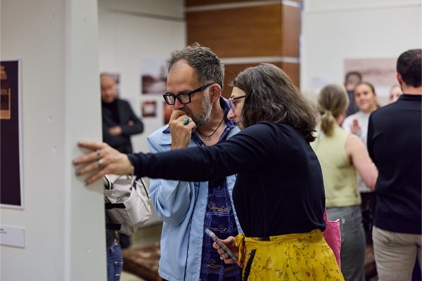 2 people look at a display at the Vollendorf exhibit. 