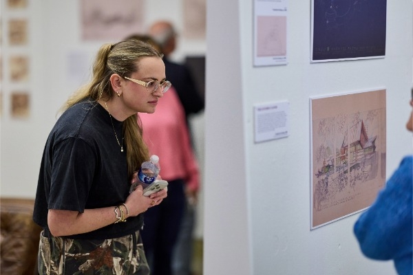 A woman looks closely to a display during the Vollendorf opening reception. 