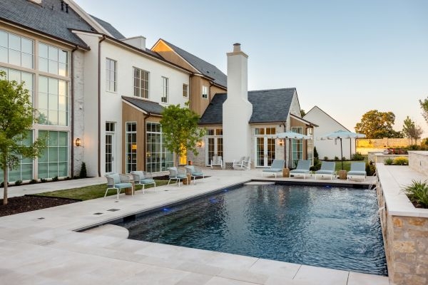 Rear exterior view of house designed by Ali Ames, featuring a large swimming pool.